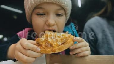 孩子吃比萨饼奶酪四。 在户外餐馆里，一群年轻的女孩子在吃披萨和咀嚼。 儿童